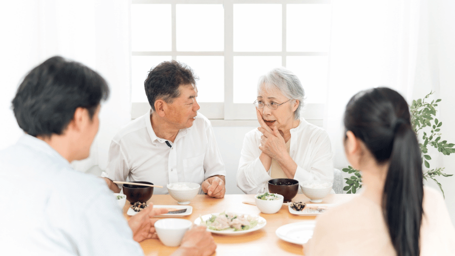 家族との食事中に頬を押さえて歯の違和感を訴える老婦人