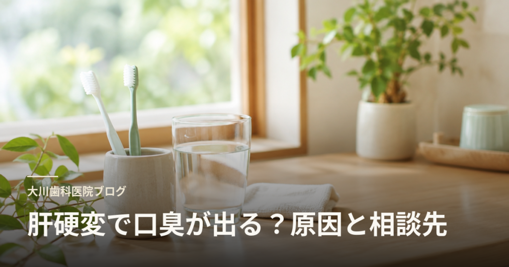 日光が差す木の机の上に歯ブラシが入った容器とグラス、水と観葉植物が写る、歯科ブログのヒーロー画像。見出しは「肝硬変で口臭が出る？原因と相談先」。