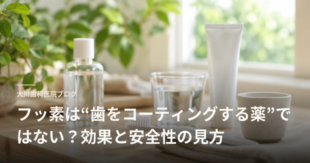 Blog header for a dental blog showing toothpaste, a bottle, glass of water and cup on a wooden table with plants in the background; Japanese headline about fluoride’s role and safety.